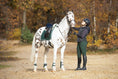 Load image into Gallery viewer, Southlake Paws Pine Grove Open-front Boots on a horse, with a rider in a black helmet and green riding pants in an autumn set