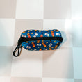 Load image into Gallery viewer, Chicago Handshake Poop Bag Holder by Southlake Paws, featuring a colorful design with bottles on a blue background.