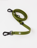 Load image into Gallery viewer, Olive green adjustable dog leash with black clips and logo, coiled on a white background. Ideal for pet owners.
