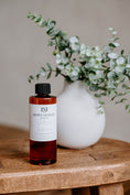 Load image into Gallery viewer, Luxury Electric Diffuser 8 OZ Refill by Southlake Paws, displayed next to a vase with greenery on a wooden table.