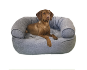 Brown dog resting on a gray premium orthopedic donut dog bed by Bowsers Pet Products