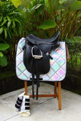 Load image into Gallery viewer, Holographic Saddle Pad by Southlake Paws displayed with a black saddle and matching horse boots on a wooden stand.
