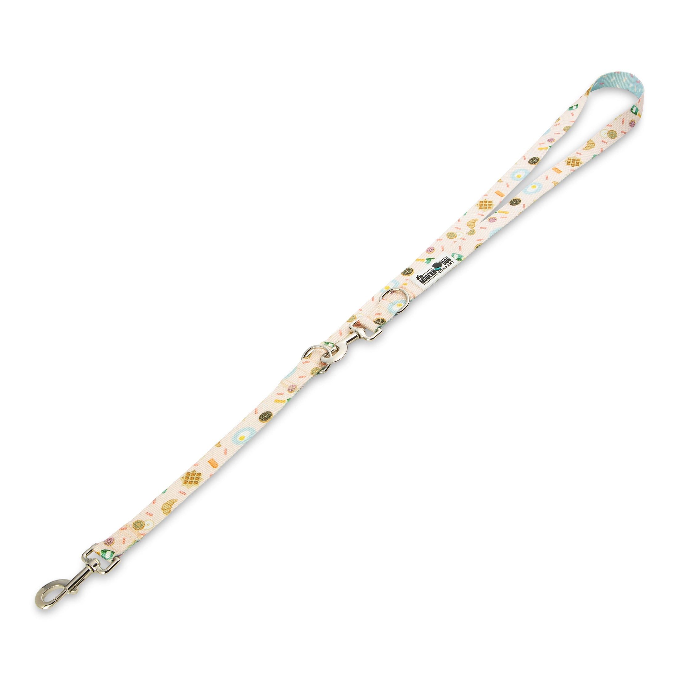 Colorful dog leash featuring a playful brunch-themed pattern with donuts, waffles, and coffee cups on a light pink background