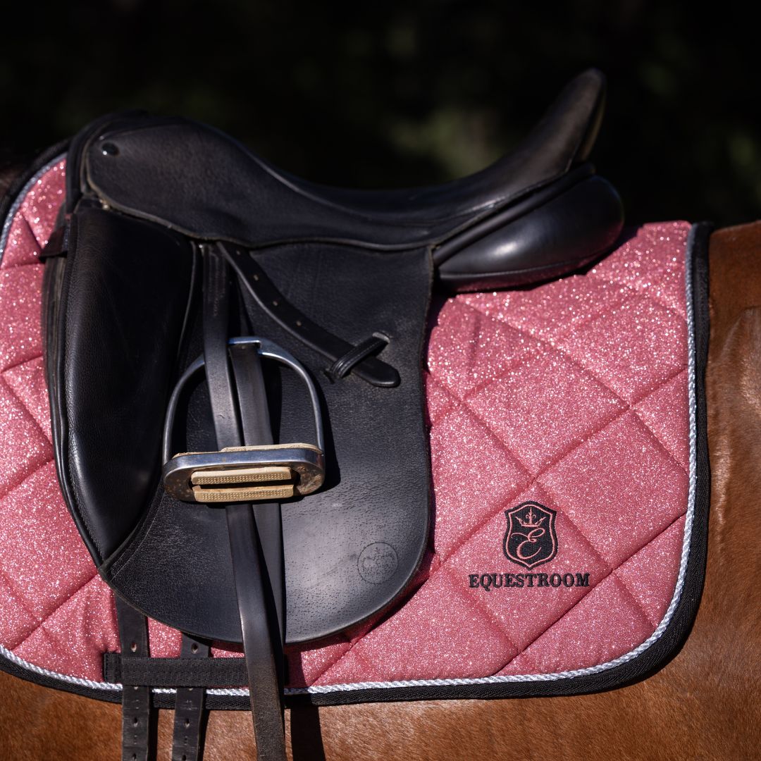 Rose Quartz Saddle Pad by Southlake Paws, featuring a sparkling pink design with a black saddle and stirrup.