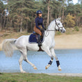 Load image into Gallery viewer, Southlake Paws Blue Astra Saddle Pad Set featuring a rider on a gray horse near a lake, showcasing equestrian gear in action.

