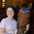 Load image into Gallery viewer, A smiling woman in a pink shirt poses with a brown horse wearing a blue Astra Browband adorned with blue and silver accents.
