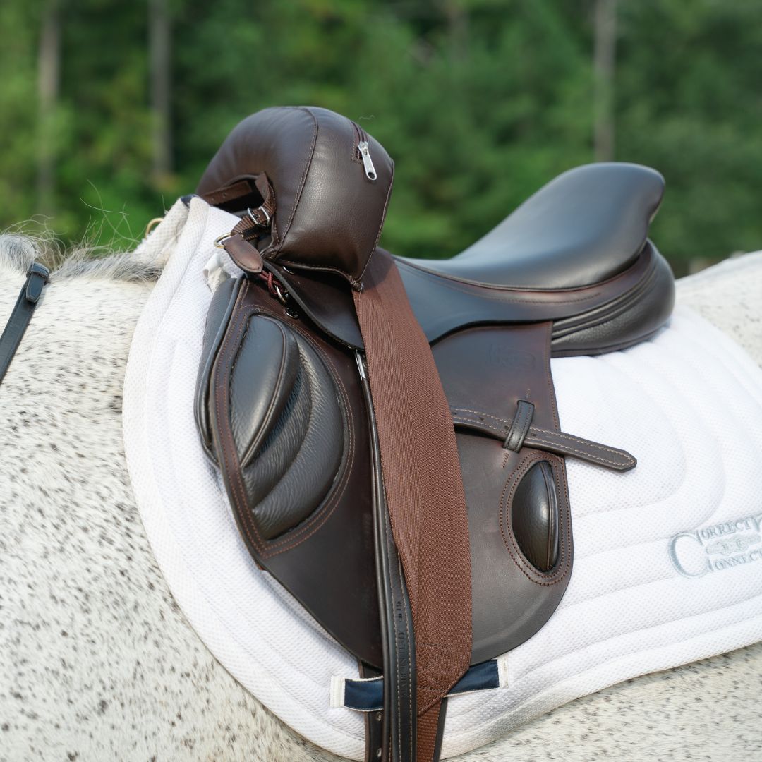 Sally Batton Pommel Blocker by Southlake Paws, a brown equestrian saddle accessory on a horse's saddle pad.