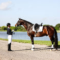 Load image into Gallery viewer, Southlake Paws B&W White Saddle Pad Set displayed on a horse by a rider near a body of water, showcasing equestrian gear.
