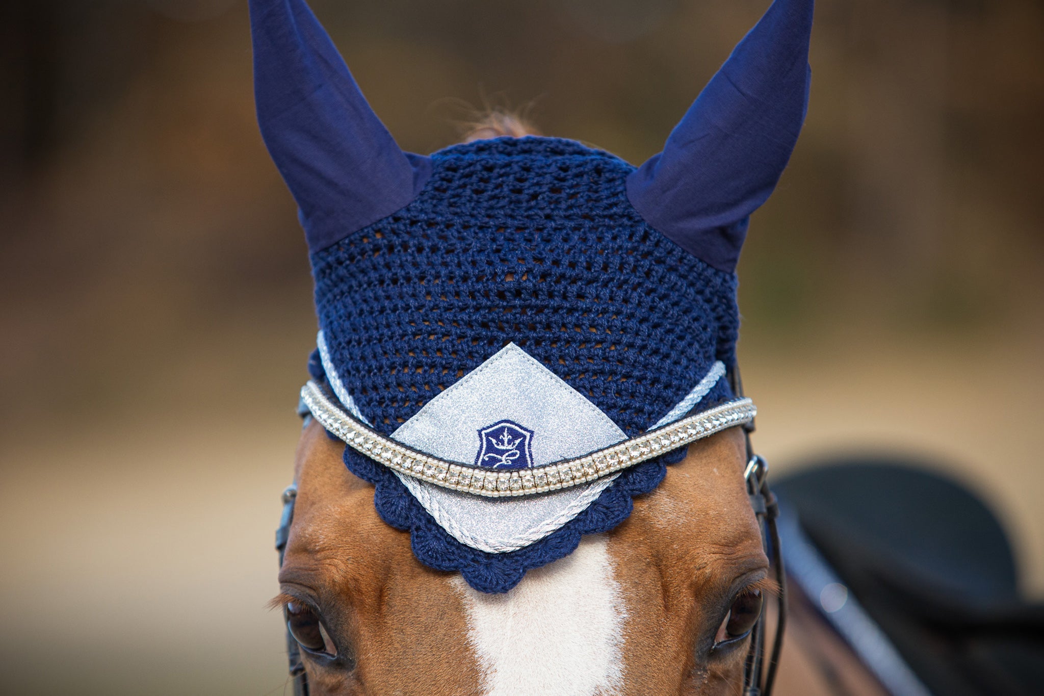 Blue Astra Saddle Pad Set by Southlake Paws featuring a navy ear bonnet with silver detailing and a decorative emblem.
