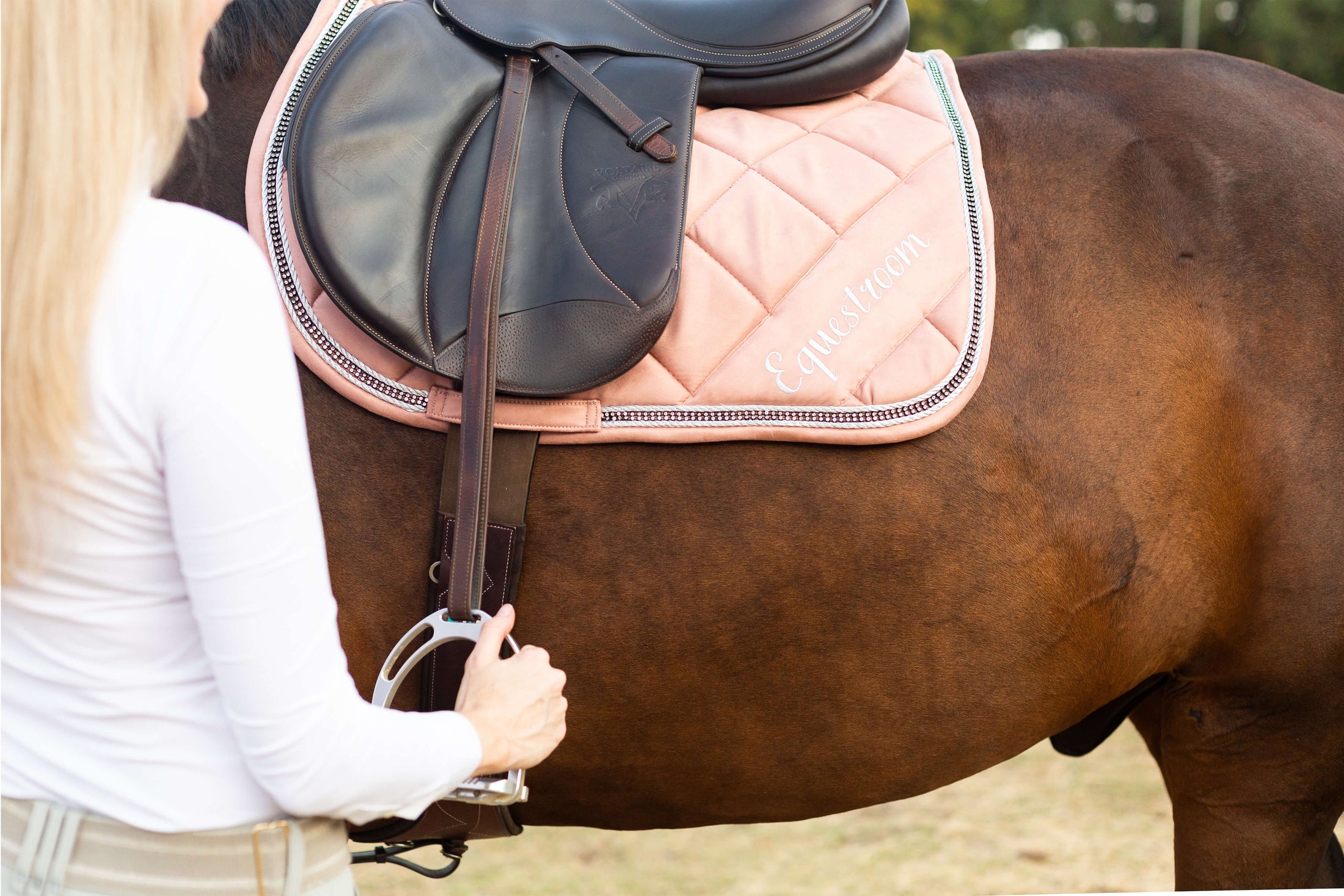 Powder Pink Suede Saddle Pad by Southlake Paws, featuring a quilted design and attached to a brown horse with a rider.