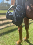 Load image into Gallery viewer, Equisole EXternal-Weighted Training Aid for Equestrians, featuring a black boot with a weighted sole, attached to a horse.
