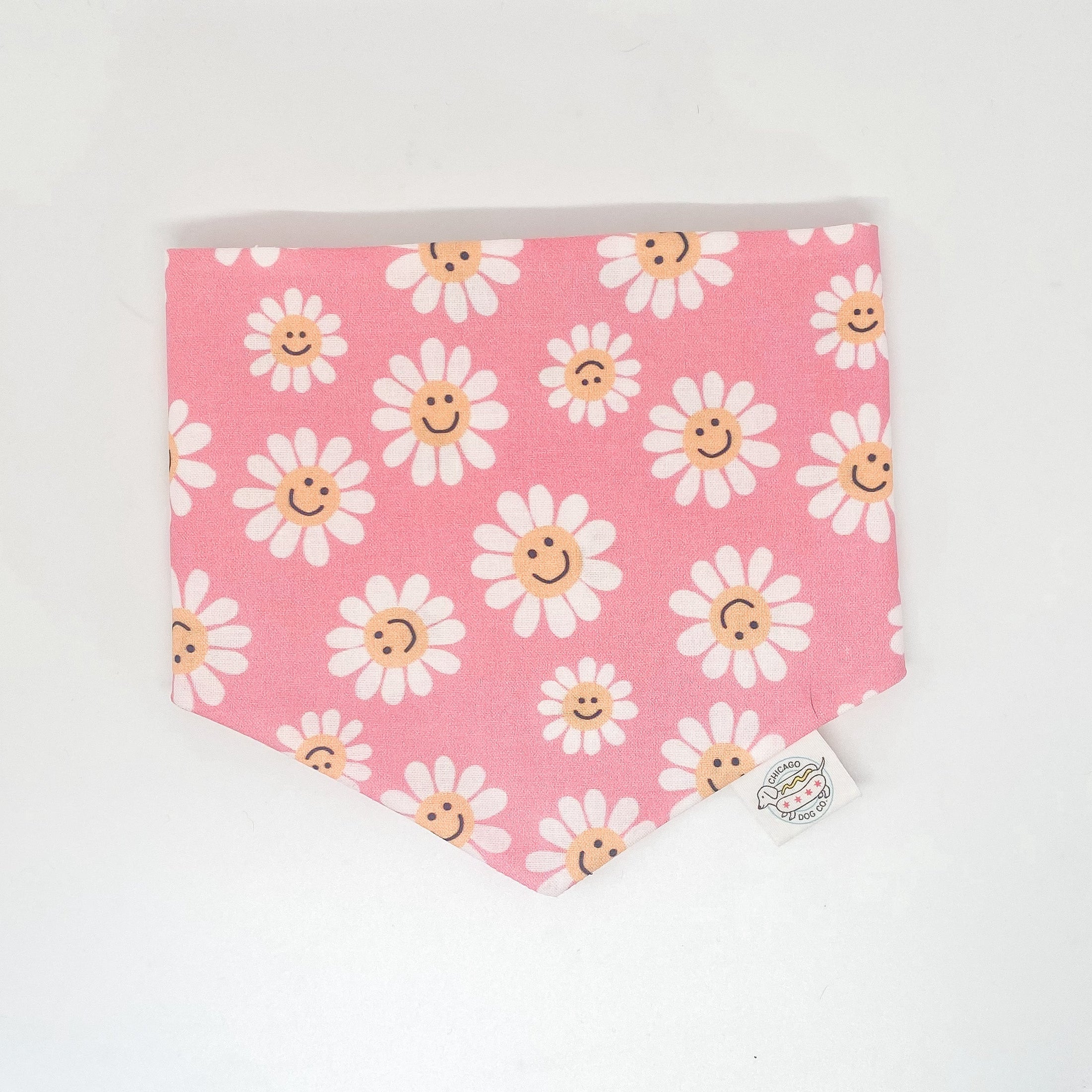 Spring Smiling Daisies Bandana by Southlake Paws featuring a pink background with smiling daisies pattern.