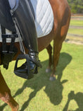 Load image into Gallery viewer, Equisole EXternal-Weighted Training Aid attached to a riding stirrup on a horse, enhancing equestrian training.
