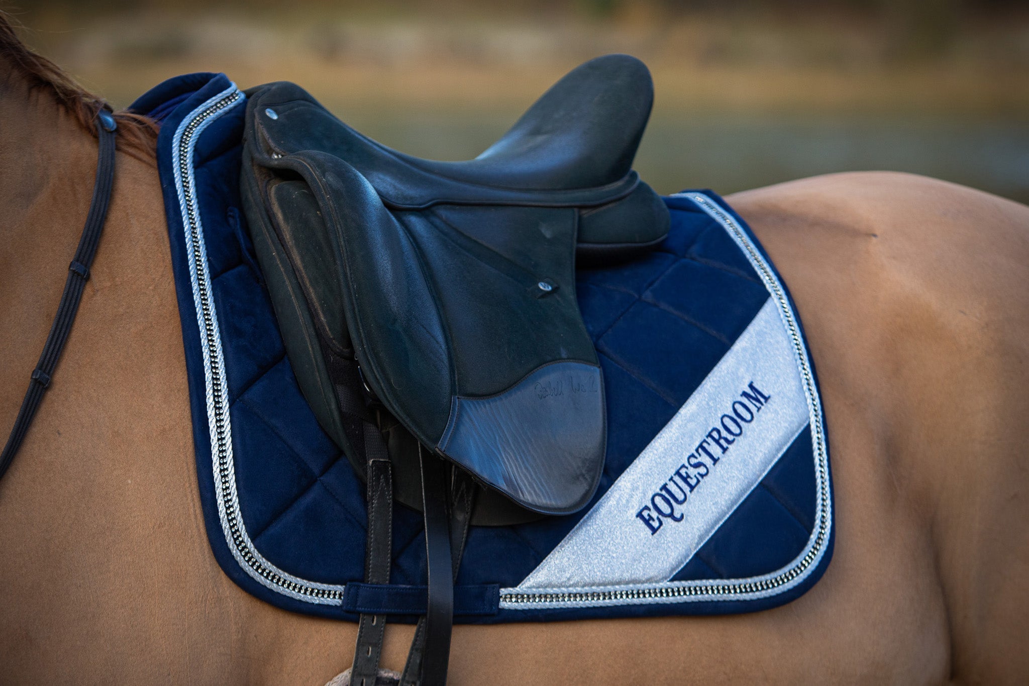 Patriot American Saddle Pad Set by Southlake Paws, featuring a navy quilted pad with silver accents and a saddle on a horse.