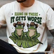 Hang In There It Gets Worse T-Shirt, White and Natural Funny Frog Tee with Dark Millennial Humor 