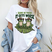 Hang In There It Gets Worse T-Shirt, White and Natural Funny Frog Tee with Dark Millennial Humor 