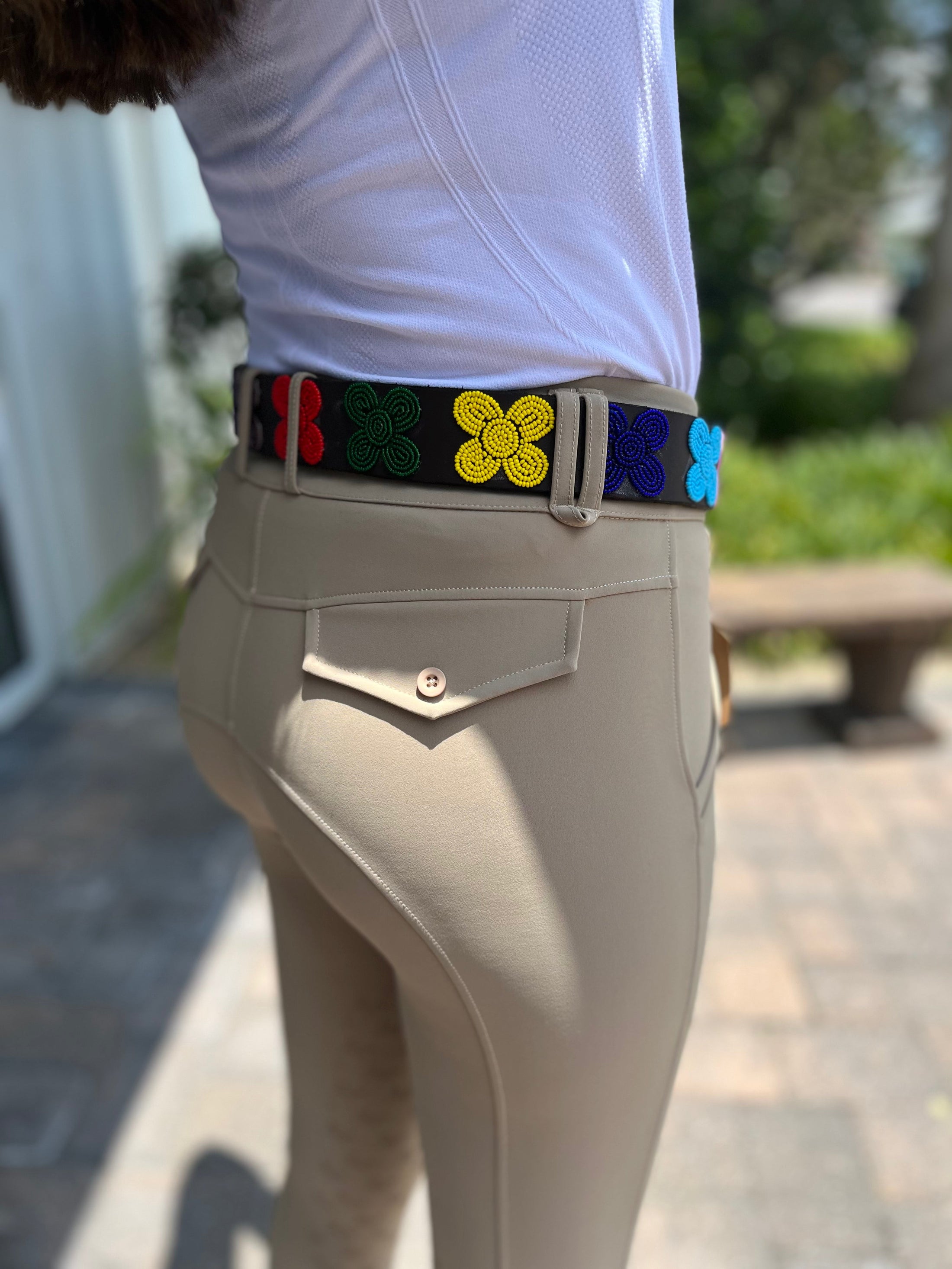 Wide width belt by Southlake Paws featuring colorful flower designs, worn with fitted beige pants.