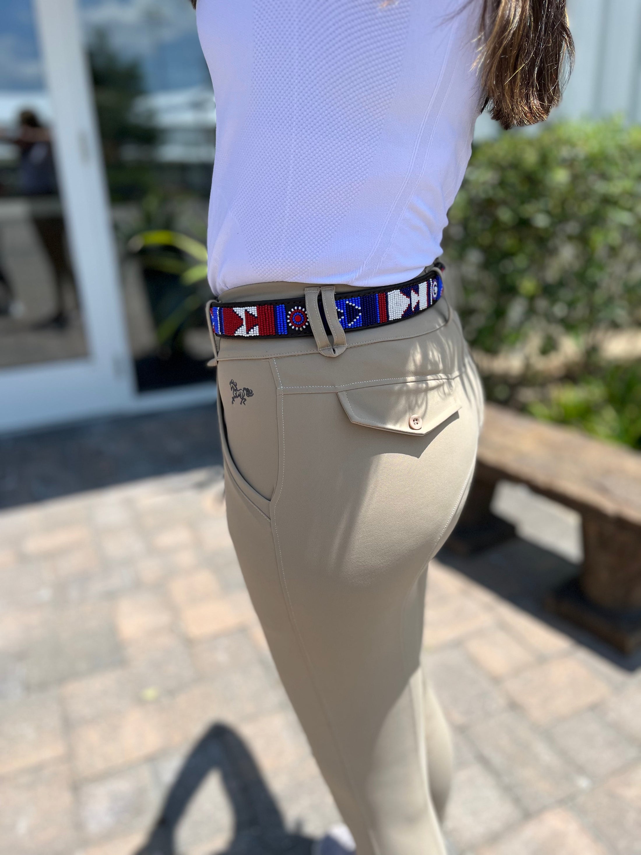 TKC Red White and Blue Belt in Wide Width with brass buckle, worn with beige riding pants, outdoors.