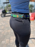 Load image into Gallery viewer, Wide width TKC Peacock Belt by Southlake Paws featuring a colorful patterned design and a brass buckle, worn with black pants
