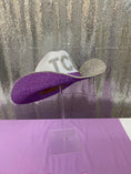 Load image into Gallery viewer, Purple and white hat with rhinestone details on a stand against a textured wall.
