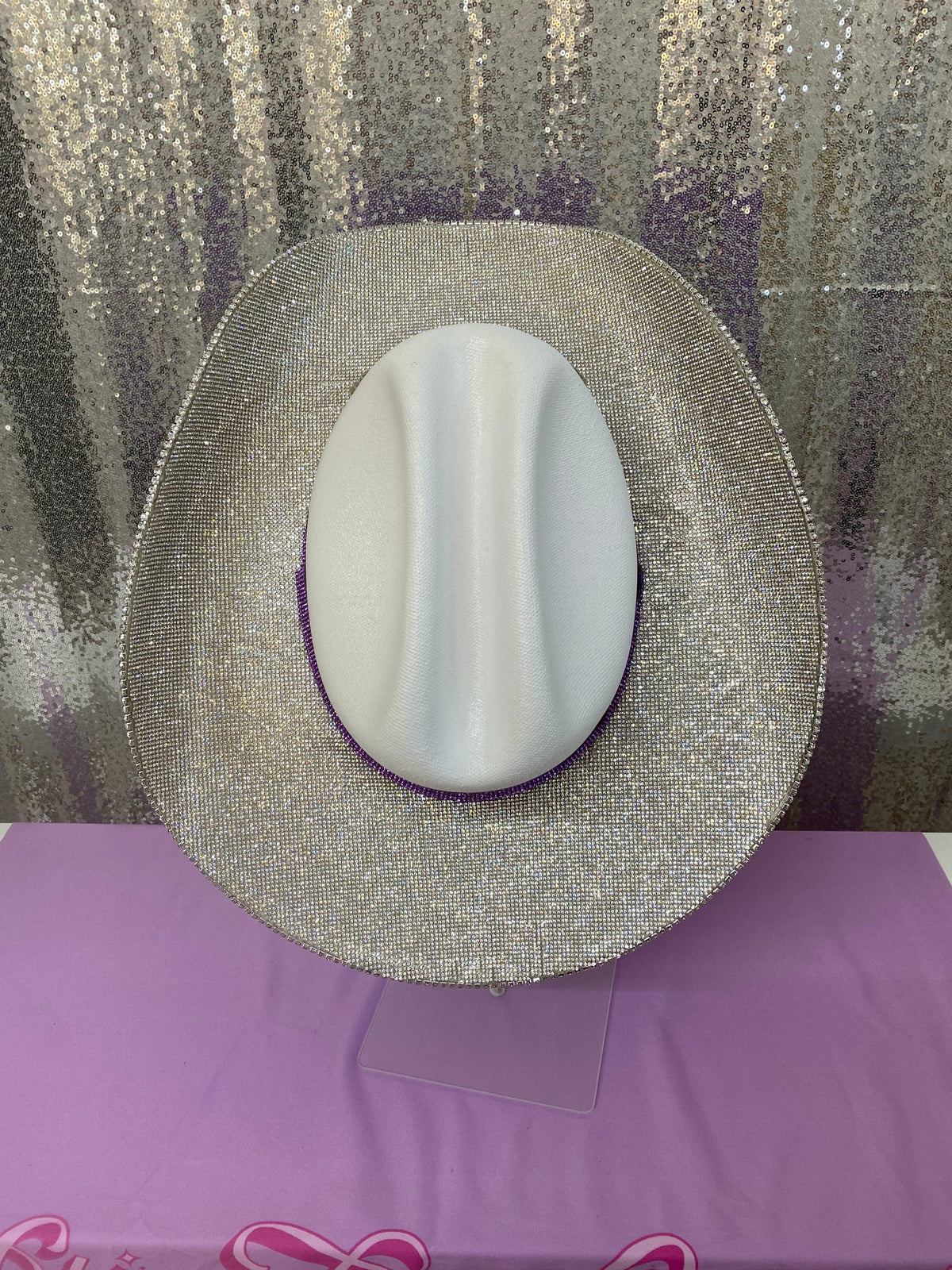 Round metallic object with a white center on a purple surface