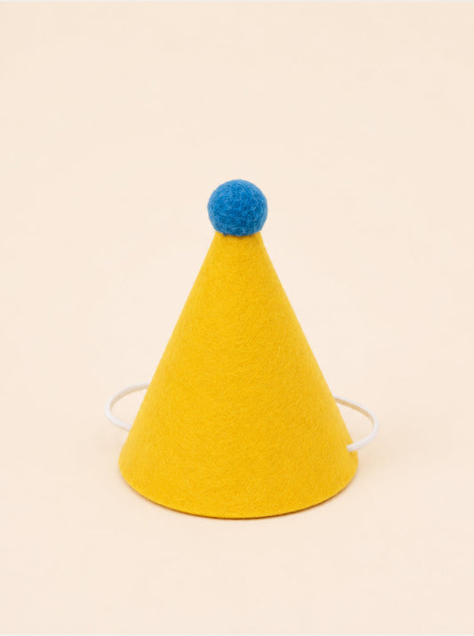 Yellow felt party hat with a blue pom-pom on top and elastic straps for secure wear. Ideal for pet celebrations.