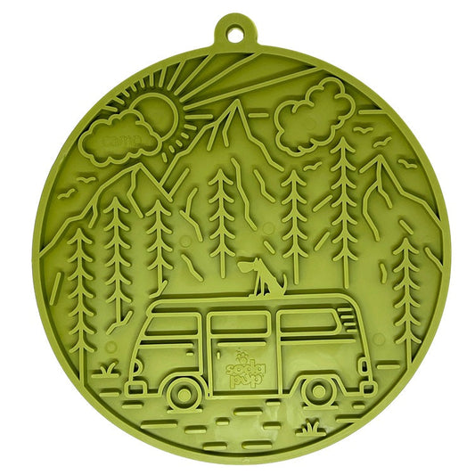 Green enrichment lick mat featuring a retro van design with mountains, trees, and a dog, equipped with suction cups.