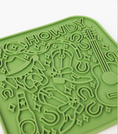 Load image into Gallery viewer, Green silicone lick mat featuring a fun cowboy theme with designs like a guitar, hat, and beer bottle, labeled "Howdy."
