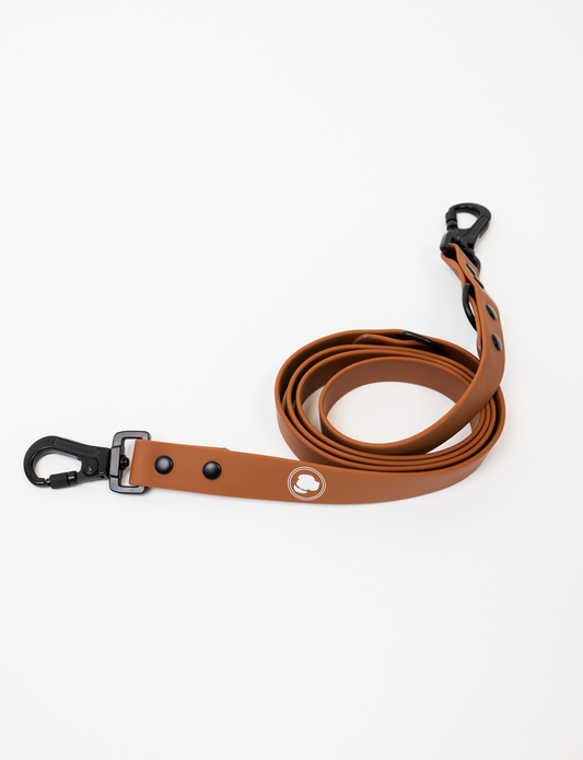Coco Brown Leash by The Modern Dog Company, featuring a sleek design with a black clip and logo, coiled on a white background