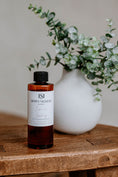 Load image into Gallery viewer, Luxury Electric Diffuser 8 OZ Refill by Southlake Paws, displayed next to a vase with greenery on a wooden table.
