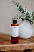 Load image into Gallery viewer, Luxury Electric Diffuser refill by Southlake Paws, 8 oz bottle with a black cap, displayed on a wooden table next to a vase.
