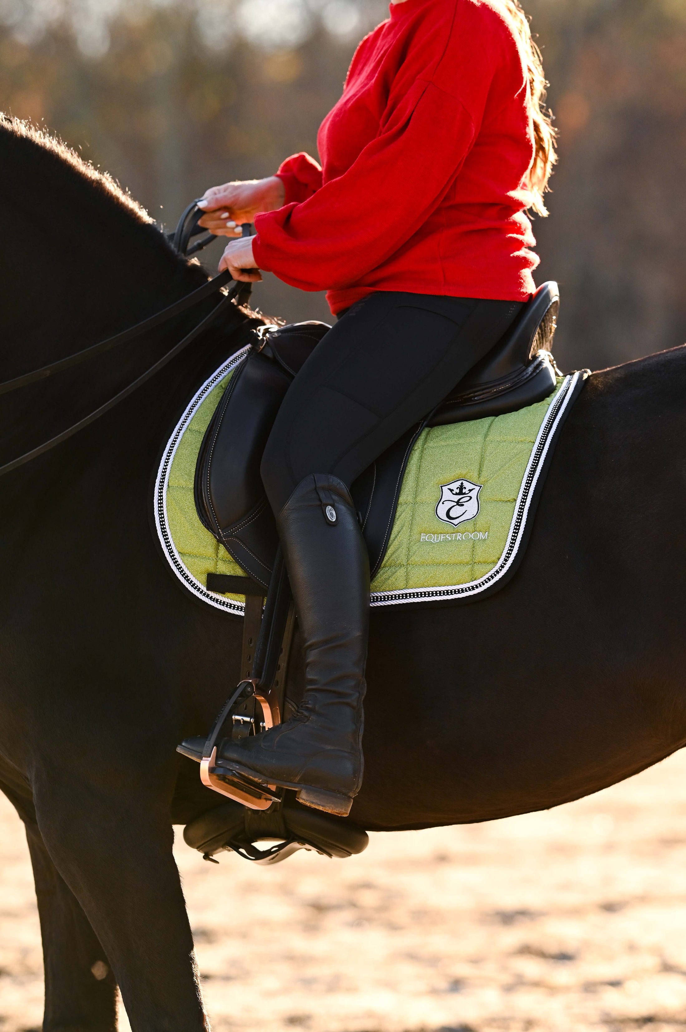 Lemongrass Saddle Pad Set by Southlake Paws, featuring a rider on a black horse, wearing a red sweater and black riding gear.