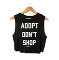 Load image into Gallery viewer, Black crop top with the text "ADOPT DON'T SHOP" in bold white letters, designed for dog lovers. Made in the USA.
