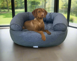 Brown dog resting on Bowsers Pet Products premium calming bed for pets in grey color
