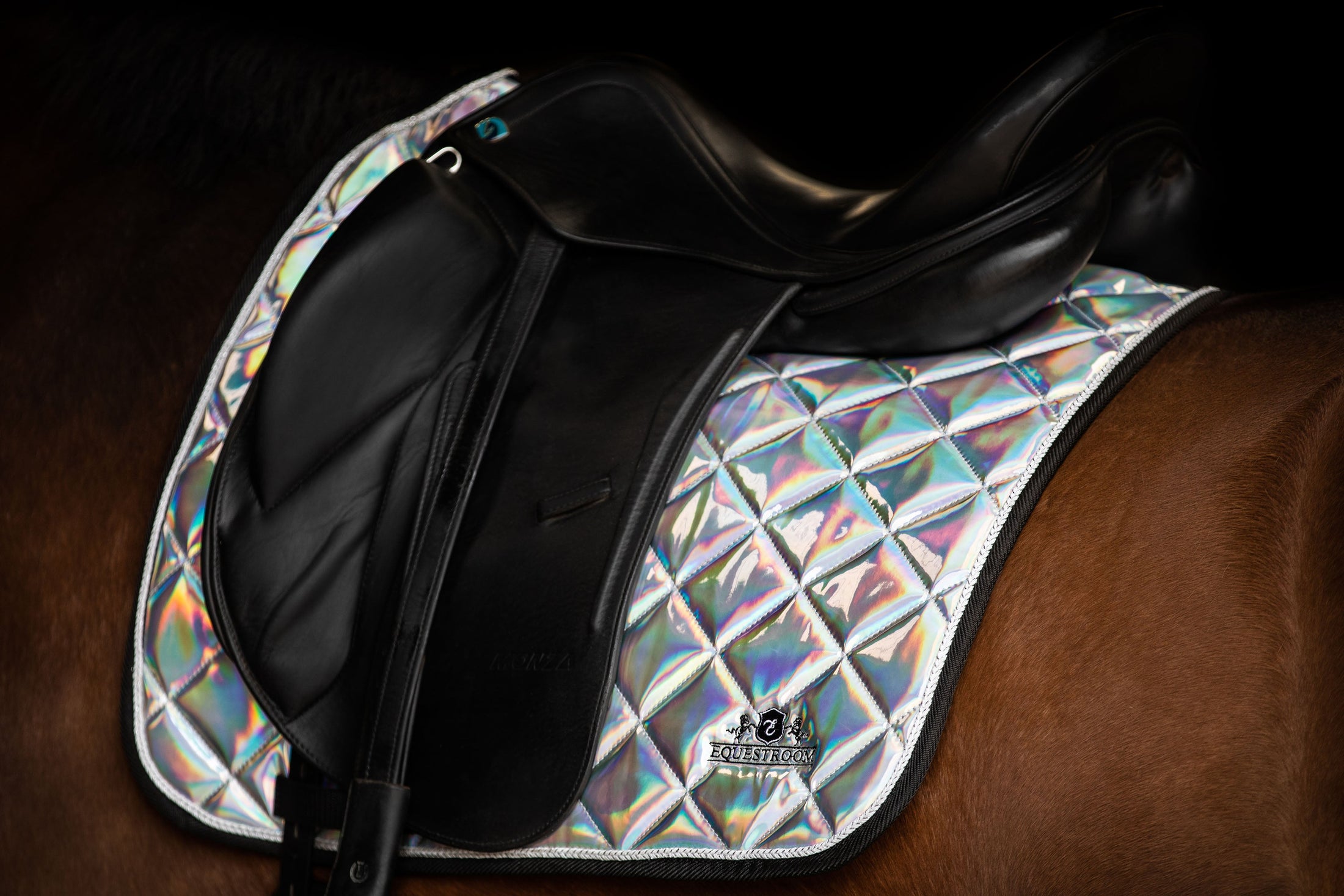 Holographic Saddle Pad by Southlake Paws, featuring a shiny, diamond-patterned design on a dark saddle.