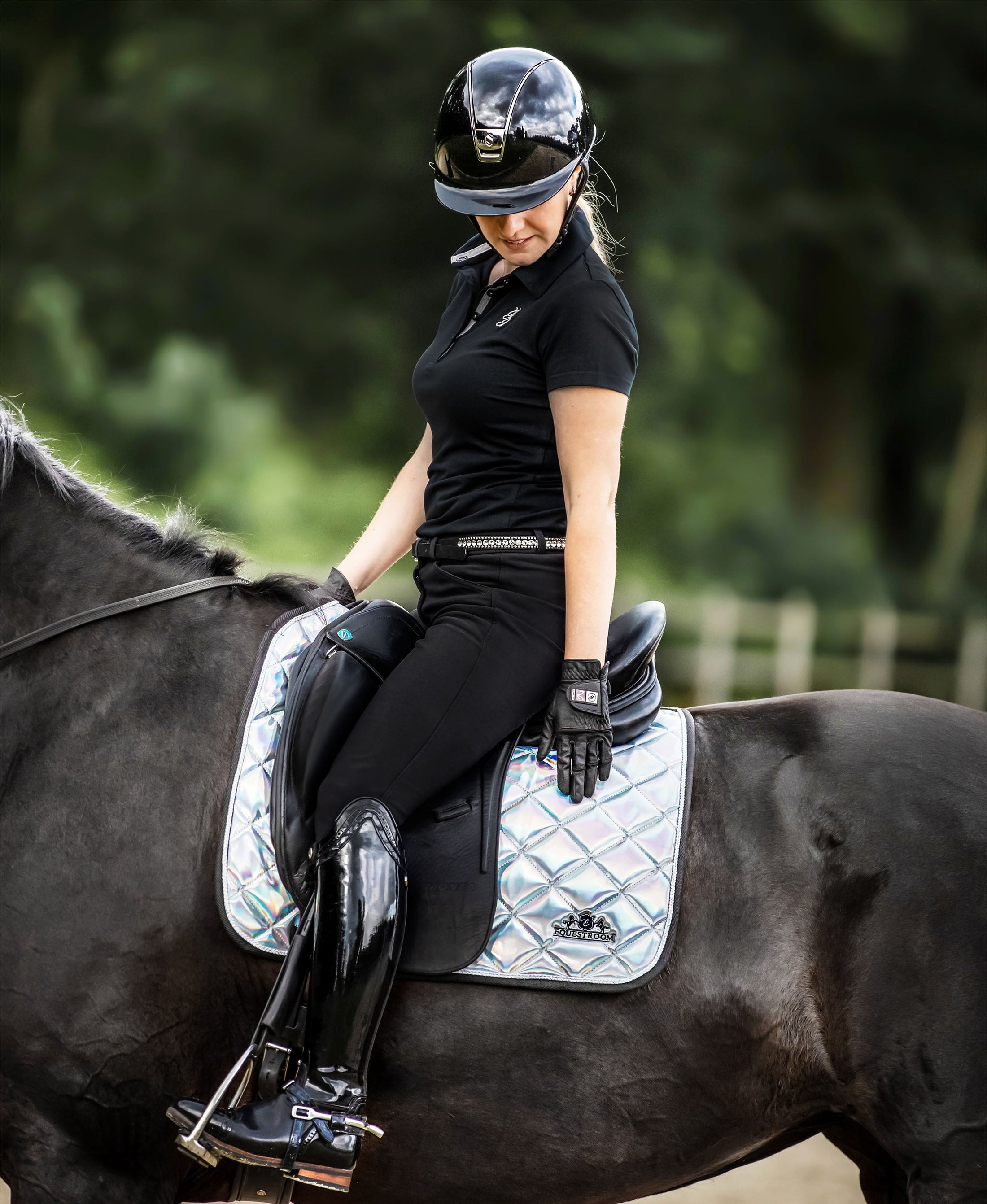 Holographic Saddle Pad by Southlake Paws on a black horse, rider in black attire, showcasing a shimmering design.