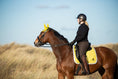 Load image into Gallery viewer, Southlake Paws Mimosa Saddle Pad in yellow on a brown horse, rider wearing a black helmet and outfit, standing in a grassy fi
