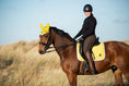 Load image into Gallery viewer, Southlake Paws Mimosa Saddle Pad on a brown horse, rider in black attire and helmet, yellow ear bonnet, sunny outdoor setting

