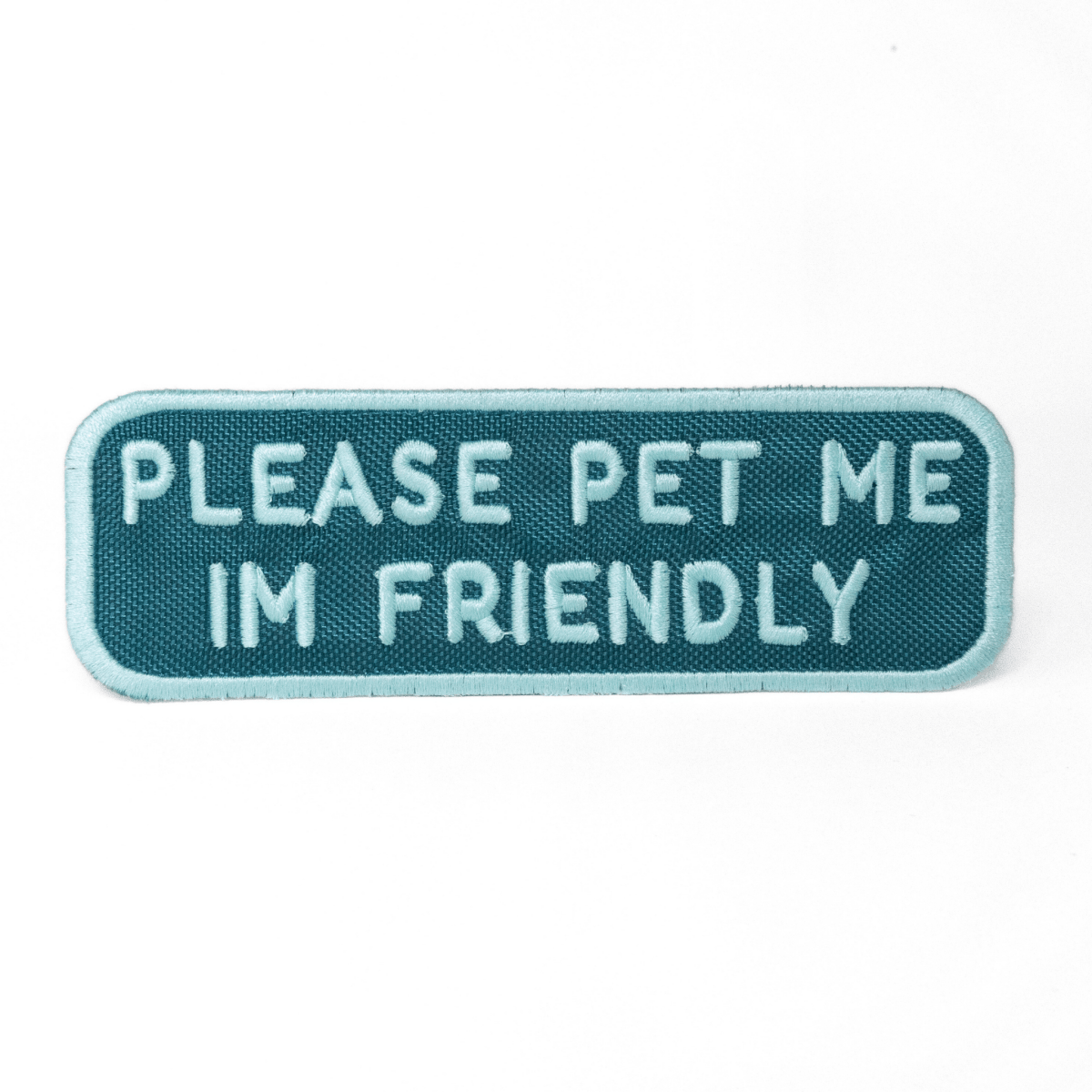 Southlake Paws Please Pet Me Patch featuring teal background with white embroidered text stating "PLEASE PET ME I'M FRIENDLY.